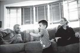  ?? ARMANDO L. SANCHEZ/CHICAGO TRIBUNE ?? David and Jessica Kulakowski watch son Chase, 3, play in Dyer, Ind. A nerve transfer and physical therapy helped him use his right arm again; he continues to build up its strength.