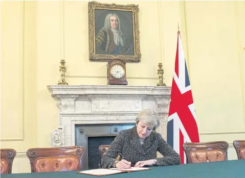  ?? EPA ?? Theresa May signing a letter of notificati­on to the President of the European Council setting out the UK’s intention to withdraw from the EU.