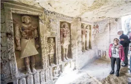  ?? Agence France-presse ?? Guests enter a newly-discovered tomb at the Saqqara necropolis, 30 kilometres south of Cairo, on Saturday, belonging to the high priest “Wahtye,” who served during the fifth dynasty reign of King Neferirkar­e (between 2500-2300 BC). The tomb is 4,400 years old.