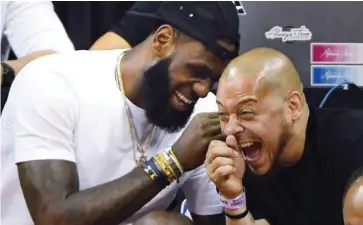  ?? (Getty Images/AFP) ?? LeBron James (left) of the Los Angeles Lakers and his friend Paul Rivera share a laugh as they attend NBA Summer League quarter-final between the Lakers and the Detroit Pistons at the Thomas &amp; Mack Centre in Las Vegas, Nevada.