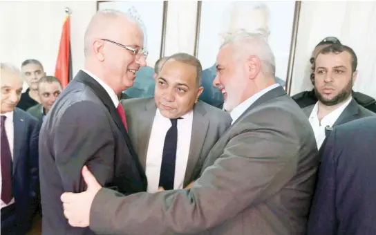  ??  ?? Palestinia­n Prime Minister Rami Hamdallah, right, shakes hands with Hamas leader Ismail Haniyeh in Gaza. (File photo/Reuters)