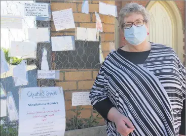  ??  ?? FAITH AND HOPE: Christine Mcwilliams reads prayers for Afghanista­n, which have been laminated and placed on an outdoor art space outside Stawell Uniting Church.