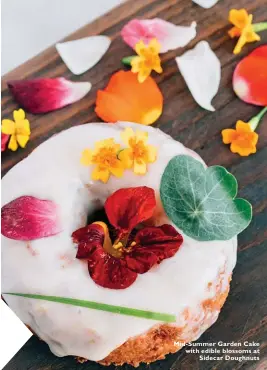  ??  ?? Mid- Summer Garden Cake with edible blossoms at Sidecar Doughnuts