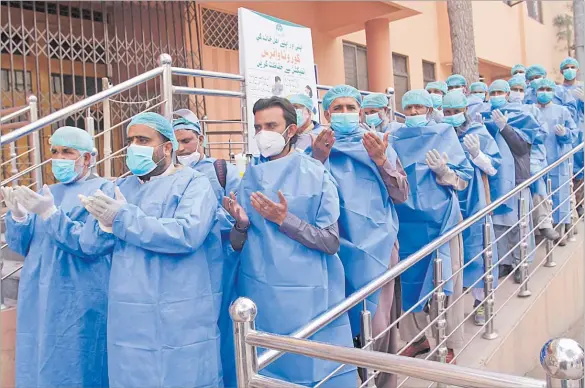  ?? Picture: AP ?? Hospital staff pray before their shift, outside a hospital setup for coronaviru­s infected patients in Quetta, Pakistan on Thursday.