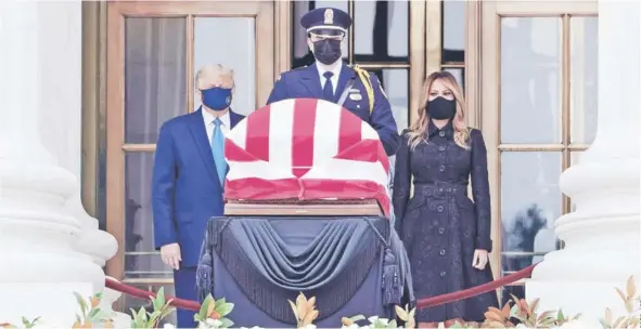 ??  ?? ► El Presidente Donald Trump, con mascarilla y acompañado de Melania, rinde tributo a la jueza Ruth Bader Ginsburg, ayer, en Washington D.C.