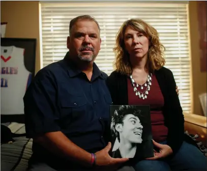  ?? NHAT V. MEYER/BAY AREA NEWS GROUP ?? Kevin and Lisa Christians­en, parents of Riley Christians­en, hold his picture in Riley’s room in their home in Clayton on Sept. 20. The photograph was taken in August 2020.