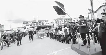  ??  ?? SELAMAT BERTUGAS: Amer melakukan simbolik melepaskan anggota Unit Rondaan Berbasikal semasa lawatan kerjanya di IPD Kuching, semalam.