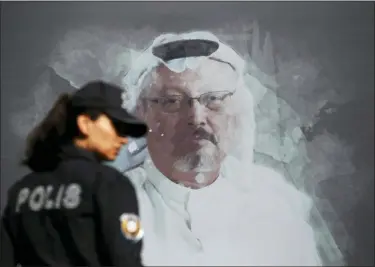  ?? LEFTERIS PITARAKIS — THE ASSOCIATED PRESS FILE ?? In this file photo, a Turkish police officer walks past a picture of slain Saudi journalist Jamal Khashoggi prior to a ceremony, near the Saudi Arabia consulate in Istanbul, marking the one-year anniversar­y of his death.