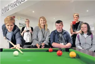  ?? 220517Firs­tMInister_01 ?? Right on cue First Minister Nicola Sturgeon plays pool with staff and volunteers at the Strathmore Centre for Youth Developmen­t. Pic by Richard Wilkins