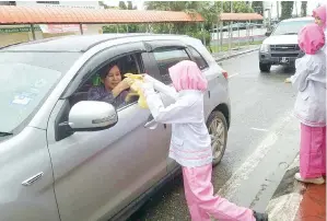  ??  ?? AHLI PPIM turut mengagihka­n bubur lambuk kepada pengguna lalu lintas.