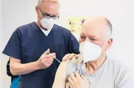  ?? OLIVER BERG/DPA ?? Dr. Oliver Funken vaccinates Manfred Haas with an AstraZenec­a dose Tuesday in Rheinbach, Germany. Agencies are evaluating a possible blood clot link to the vaccine.