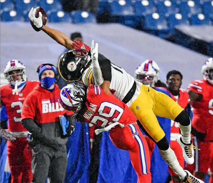  ?? Peter Diana/Post-Gazette photos ?? The football slips away from Steelers wide receiver Chase Claypool as he reaches high in an attempt to catch a pass as Bills cornerback Josh Norman defends.