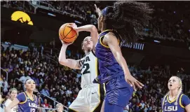  ?? Andy Lyons/Getty Images ?? Iowa’s Caitlin Clark shoots the ball while defended by LSU’s Angel Reese on April 1 in Albany, N.Y.