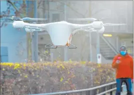  ?? Markus Schreiber The Associated Press ?? Peter Trempeck monitors the landing of a drone with a case for medical items during a presentati­on Monday in Berlin. Each drone can carry about 40 test samples.