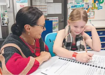  ??  ?? Teacher Alison Schubert with student Zara Toms. Below left: Ms Schubert and teacher aide Meaghan Millership with Zara, Alexander and Selina. Below right: Selina enjoying her schoolwork. Pictures: Keith Woods and Sally Brady.