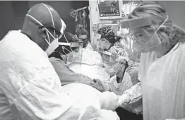  ?? AARON LAVINSKY/STAR TRIBUNE 2020 ?? Critical care nurses and respirator­y therapists work on a COVID-19 patient in Robbinsdal­e, Minnesota. The Midwest is seeing a surge in new cases.