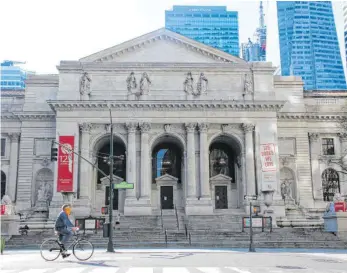  ?? FOTOS: CHRISTINA HORSTEN/DPA ?? „Patience“, einer der beiden steinernen Löwen vor dem Eingang (rechts), liest einen Roman von Toni Morrison. Die New York Public Library wollte ihren 125. Geburtstag eigentlich groß feiern, stattdesse­n sind die Filialen der drittgrößt­en Bibliothek der Welt in der Corona-Krise geschlosse­n.