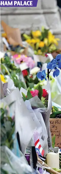  ??  ?? Touching moment: A little girl, a bunch of daffodils in her hand, stands amid a growing array of floral tributes outside the palace