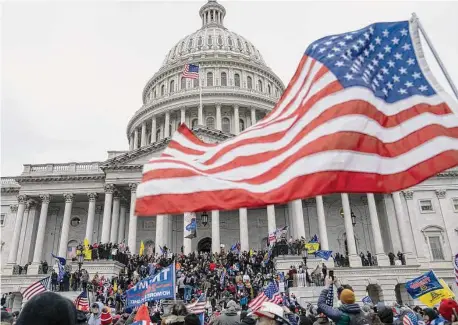  ?? Michael Robinson Chavez/The Washington Post ?? Supporters of President Donald Trump scale the walls at the U.S. Capitol on Jan. 6, 2021.