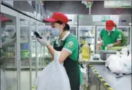  ?? FANG ZHE / XINHUA ?? An employee of online grocery platform Dingdong Maicai packs vegetables in Shanghai.