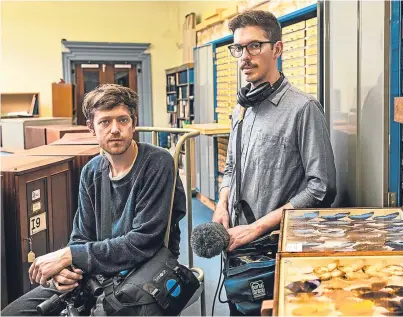  ?? Picture: Ross Fraser Maclean. ?? Artist Duncan Marquiss, left and musician Jonnie Common delve into the McManus Collection­s Unit, Dundee as part of their project Drawn to Light, which will be projected on to the outside of the museum and art gallery.