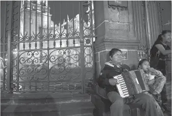  ??  ?? A man plays the accordion outside the Cathedral at Zocalo in Puebla.
