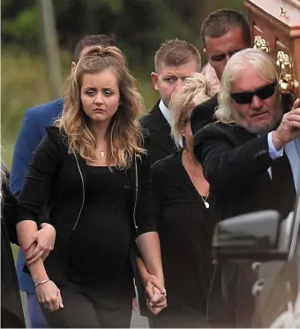  ??  ?? William Dunlop’s pregnant partner Janine (left) follows his coffin during the funeral at Garryduff Presbyteri­an Church near Ballymoney, Co Antrim. Photo: Colm Lenaghan/ Pacemaker