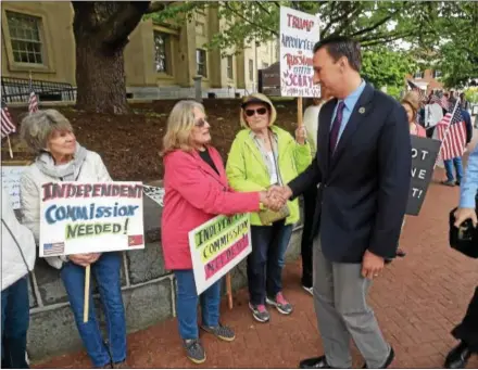  ?? PETE BANNAN — DIGITAL FIRST MEDIA ?? Congressma­n Ryan Costello shakes hands with Rozy Kleaver of West Chester as he passes protesters who gather every Friday outside his West Chester office.