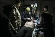  ?? EVGENIY MALOLETKA — THE ASSOCIATED PRESS ?? Ukrainian military medics treat their wounded comrade at a field hospital near Bakhmut, Ukraine, Wednesday.