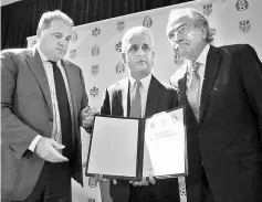  ??  ?? United States Soccer Federation (USSF) president Sunil Gulati (centre), Canadian CONCACAF president Victor Montaglian­i (left) and Mexican Football Federation president Decio De Maria hold up a signed unified bid for the 2026 World Cup in New York City....