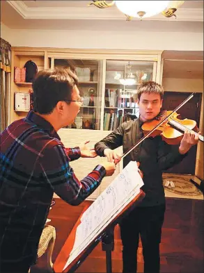  ?? PHOTOS PROVIDED TO CHINA DAILY ?? Wang Zi’an practices viola with his teacher Hou Donglei in Guangzhou, Guangdong province.