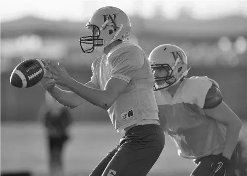  ?? SHAUGHN BUTTS/ EDMONTON JOURNAL ?? University of Alberta Golden Bears quarterbac­k Curtis Dell takes a shotgun snap during practice at Foote Field earlier this week.