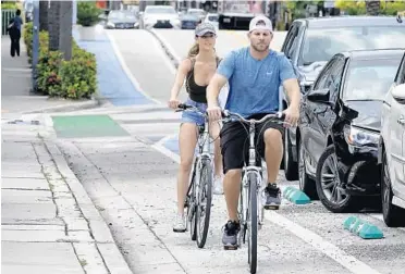  ?? JOE CAVARETTA/SUN SENTINEL ?? Bicyclists ride in the shared bicycle and parking lanes on East Las Olas Boulevard. A three-block section of plastic poles and painted bike lanes will remain in place for now, as the city of Fort Lauderdale weighs whether to make the pedestrian safety improvemen­ts permanent.