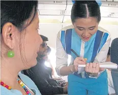  ??  ?? A Bangkok Airways flight attendant takes orders.