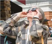  ?? ?? Connie Laarendi watchs the solar eclipse Monday at the Promenade Shops.