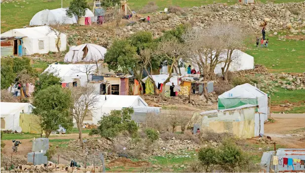  ?? —AP photo ?? Syrian villagers next to their tents near the village of Beerjam, on the Syrian side of the Golan Heights, seen from the Israeli-controlled Golan Heights. Children and families who are allowed into Israel as part of its ‘Good Neighbours’ programme...