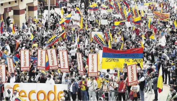  ?? CARLOS ORTEGA / EFE ?? Numerosos manifestan­tes marchan por las calles de Bogotá, ayer, en una nueva jornada de protestas.