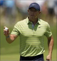  ?? AP PHOTOS ?? OUT IN FRONT: Rory McIlroy waves after making a putt on the first hole during the first round of the PGA Championsh­ip on Thursday in Tulsa, Okla. At left, Tiger Woods watches his shot on the 15th hole.