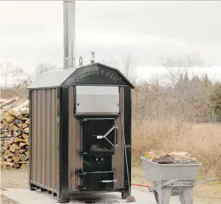  ?? STEVE MAXWELL ?? Outdoor wood furnaces like this one can heat large buildings and domestic hot water. Canada has many rural areas with ample wood that can be used to replace electricit­y used to produce heat.
