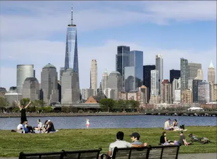  ?? Seth Wenig/Associated Press ?? People enjoy the good weather while keeping their distance from one another Saturday at Liberty State Park in Jersey City, N.J., with New York City in the background.