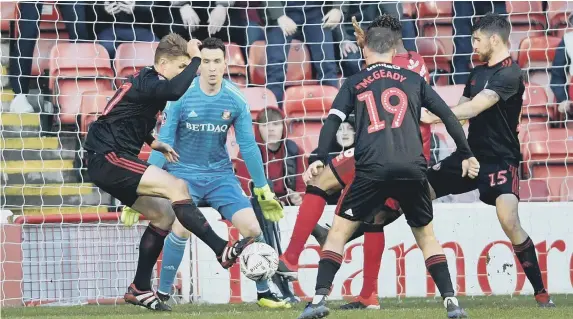  ??  ?? Max Power, left, helps Sunderland clear their lines.