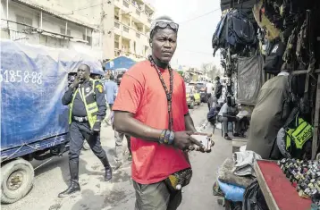  ?? SYLVAIN CHERKAOUI AP ?? Gueva Ba sells used cellphones in Dakar, Senegal, on Feb. 1. Ba, who tried 11 times to reach Europe via Morocco, flew legally to Nicaragua and traveled north illegally by land and entered the U.S. He was deported in September.