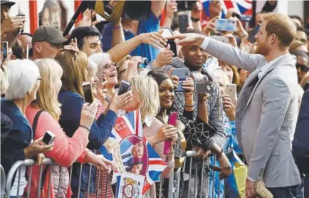  ?? Odd Andersen, AFP/Getty Images ?? Prince Harry greets well-wishers on the street outside Windsor Castle on Friday, the eve of his wedding to Meghan Markle.