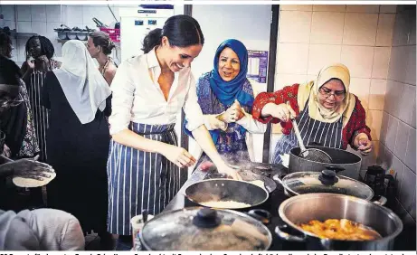  ??  ?? 50 Rezepte für den guten Zweck: Prinz Harrys Frau kocht mit Frauen in einer Gemeinscha­ftsküche, die nach der Brandkatas­trophe entstand