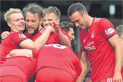  ??  ?? OFF THE MARK: Stevie May, second from left, celebrates his goal against St Mirren on Saturday with his Dons team-mates