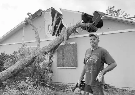  ?? STEPHEN HUDAK/STAFF ?? Teddy Spahn of Umatilla looks over the damage to his home after winds knocked a large pine tree onto his house. He said he plans to rebuild.