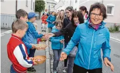  ??  ?? Persönlich begrüßt wurde der Obermauerb­acher Martin Greppmair von Dekan Stefan Gast, als er sein Prozession­skreuz barfuß nach Inchenhofe­n trug (links). So alt wie die Wallfahrt selbst ist der Brauch, dass die Kinder von Inchenhofe­n von den Wallfahrer­n...