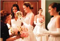  ??  ?? Claire Chlebowski, center, of Houston, receives her bouquet of roses at the start of the Internatio­nal Debutante Ball.