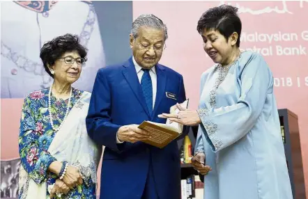  ?? — Bernama ?? Page-turner: Dr Mahathir and his wife Tun Dr Siti Hasmah Mohamad Ali being briefed by Bank Negara Malaysia governor Datuk Nor Shamsiah Mohd Yunus on the book ‘ Tun Ismail Ali – A Paragon of Trust and Integrity’ during its launch at Sasana Kijang, Kuala Lumpur.