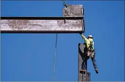  ?? MATT ROURKE / AP ?? An ironworker guides a beam during constructi­on of a municipal building in Norristown, Pa., on Feb. 15. The strength of the American job market has consistent­ly defied expectatio­ns throughout the economic tumult of the COVID years.